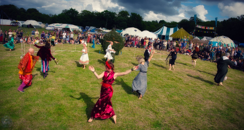 People dancing in a field at Buddhafield Festival 